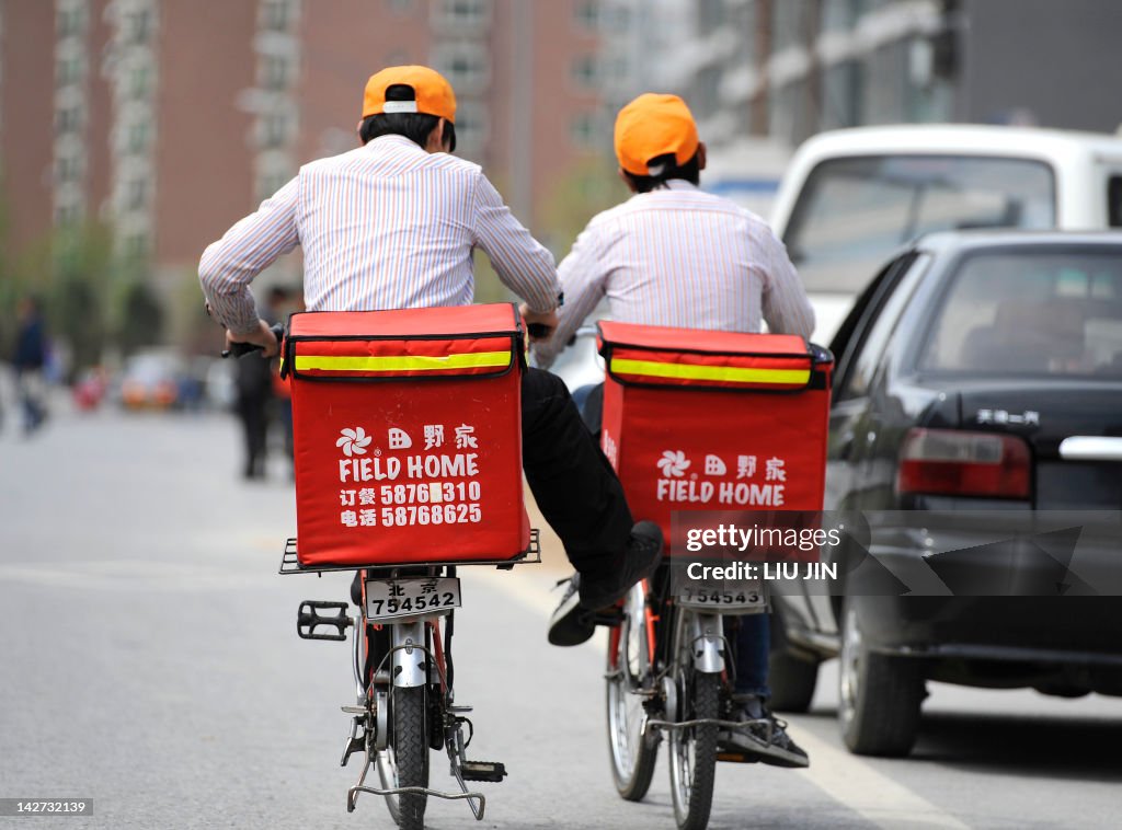 Two workers ride bicycles to deliver fas