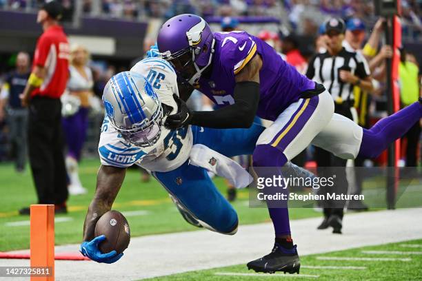 Running back Jamaal Williams of the Detroit Lions fights his way with cornerback Patrick Peterson of the Minnesota Vikings into the end zone for a...