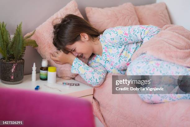 teenage girl crying in pillow in pain - gastroenteritis stock pictures, royalty-free photos & images