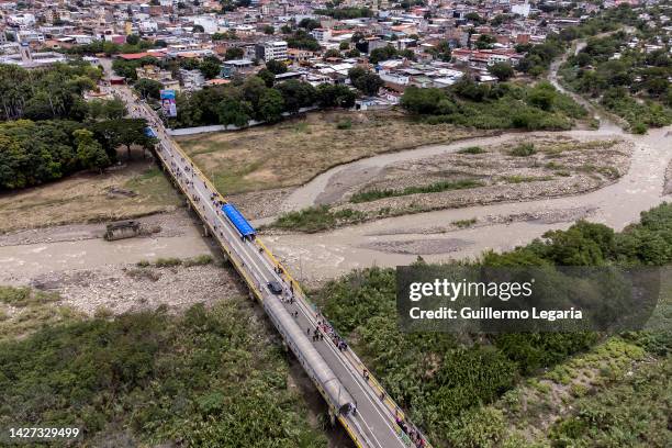 Aerial view of pedestrians crossing the international bridge Simon Bolivar ahead of the commercial border reopening between Venezuela and Colombia on...