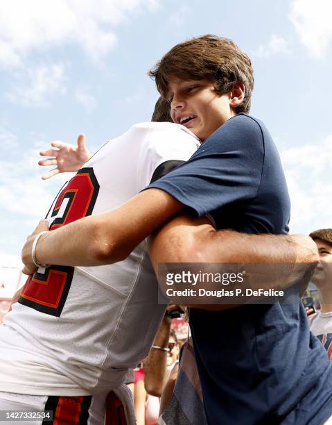 Tom Brady of the Tampa Bay Buccaneers hugs his son John Edward Thomas Moynahan on the sidelines prior to the game against the Green Bay Packers at...