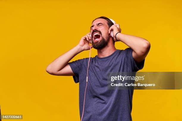 copy space photo of an exited caucasian man singing inspired with closed eyes. - hands covering ears stock pictures, royalty-free photos & images