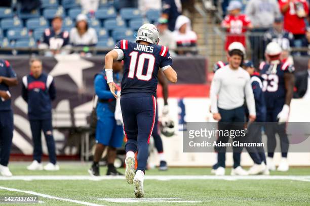 Quarterback Mac Jones of the New England Patriots jogs towards the sideline after an injury during the fourth quarter against the Baltimore Ravens at...