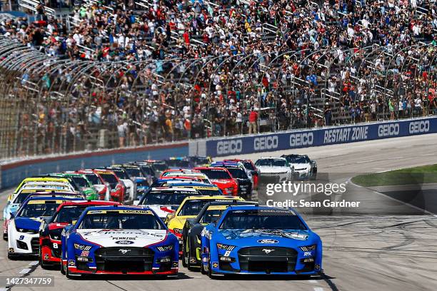 Brad Keselowski, driver of the RoushParts.com Ford, and Joey Logano, driver of the AAA Insurance Ford, lead the field to start the NASCAR Cup Series...