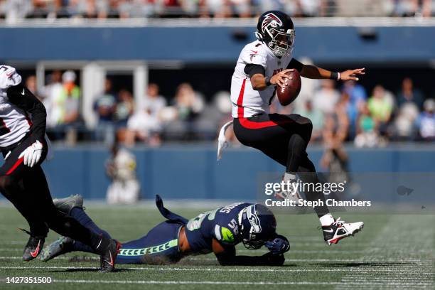 Marcus Mariota of the Atlanta Falcons jumps over Jordyn Brooks of the Seattle Seahawks during the first half at Lumen Field on September 25, 2022 in...