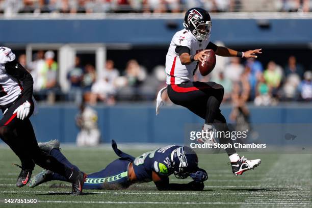 Marcus Mariota of the Atlanta Falcons jumps over Jordyn Brooks of the Seattle Seahawks during the first half at Lumen Field on September 25, 2022 in...