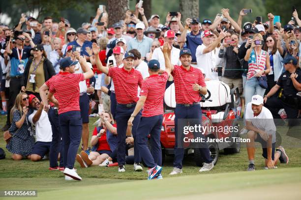 The United States Team celebrate on the 18th green after teammate Xander Schauffele won 1 Up against Corey Conners of Canada and the International...