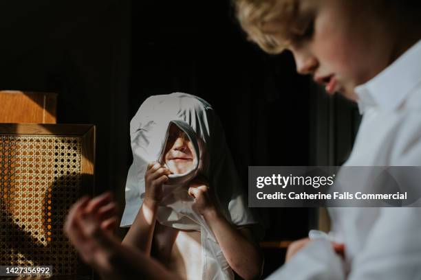 relatable image of a child attempting to dress herself before school, getting stuck in the fresh white shirt as she does so - buttoning stock pictures, royalty-free photos & images