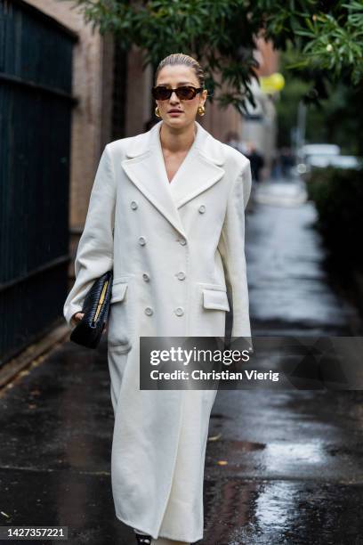 Eleonora Carisi wears white oversized double breasted coat, black bag outside Ermanno Scervino during the Milan Fashion Week - Womenswear...