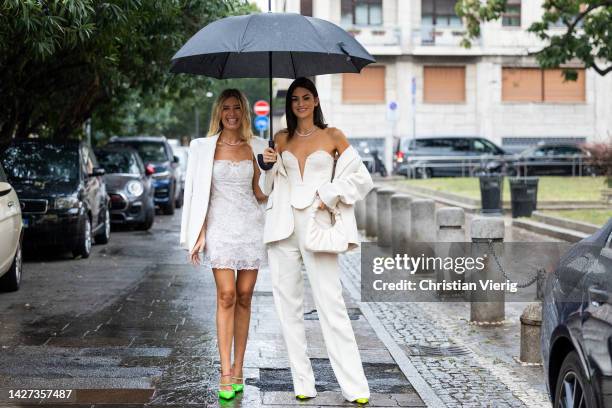 Teresa Andres Gonzalvo wears white laced dress, blazer and Marta Lozano wears white off shoulder top, bag, blazer, pantsoutside Ermanno Scervino...