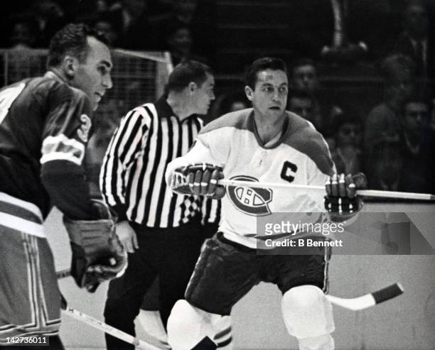 Jean Beliveau of the Montreal Canadiens skates on the ice as he is defended by Harry Howell of the New York Rangers on October 24, 1965 at the...