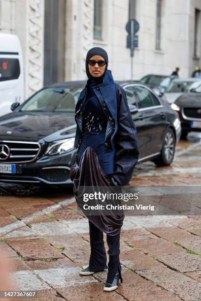 Guest wears head scarf, brown pleated skirt, jacket, boots outside Philosophy during the Milan Fashion Week - Womenswear Spring/Summer 2023 on...