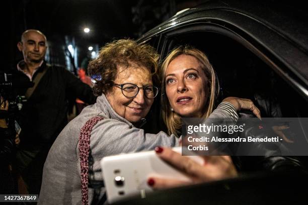 Conservative party Brothers of Italy President Giorgia Meloni greets and takes a selfie with a supporter after casting her vote at a polling station...