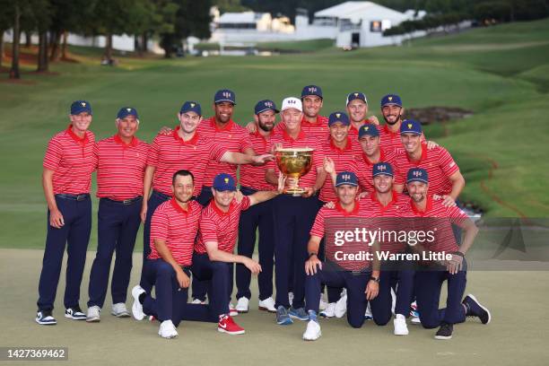 Captain Davis Love III of the United States Team poses with the Presidents Cup alongside the team during the closing ceremony after defeating the...