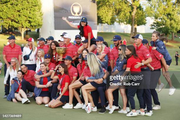 Captain Davis Love III of the United States Team pose with the Presidents Cup alongside the team and their wives and girlfriends during the closing...