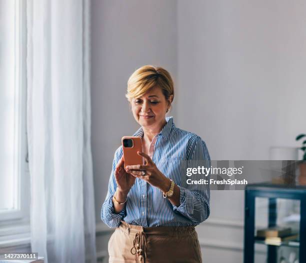 a confused beautiful businesswoman using her mobile phone while - cell phone confused stock pictures, royalty-free photos & images