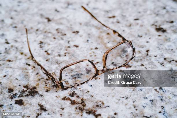 tortoise shell eyeglasses on speckled granite counter - tortoiseshell pattern stock pictures, royalty-free photos & images