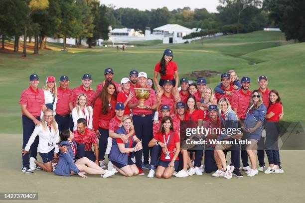 Captain Davis Love III of the United States Team poses with the Presidents Cup alongside the team and their wives and girlfriends during the closing...