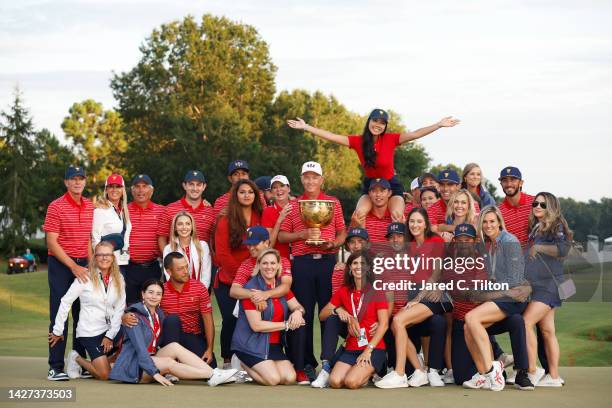 Captain Davis Love III of the United States Team poses with the Presidents Cup alongside the team and their wives and girlfriends during the closing...