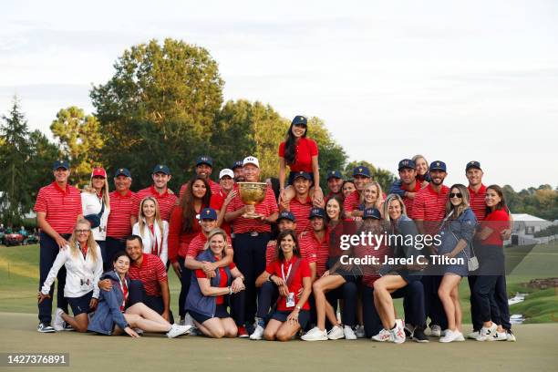 Captain Davis Love III of the United States Team poses with the Presidents Cup alongside the team and their wives and girlfriends during the closing...