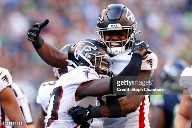 Richie Grant of the Atlanta Falcons is congratulated by Jaylinn Hawkins after making an interception against the Seattle Seahawks during the fourth...