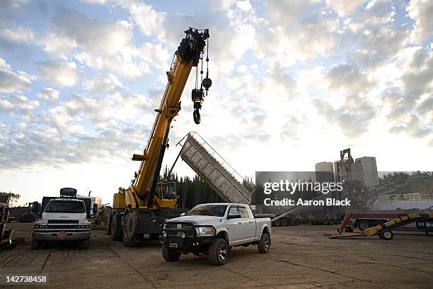 large pick-up under a crane, with other equipment - crane construction machinery foto e immagini stock