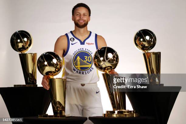 Stephen Curry of the Golden State Warriors poses with the four Larry O'Brien Championship Trophies that he has won with the Warriors during the...