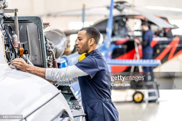 mecánicos de aviones trabajando en hangar de helicópteros - fuselage fotografías e imágenes de stock