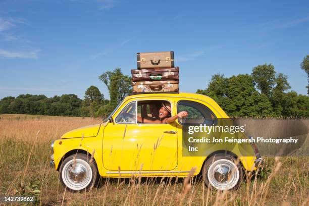 couple in old-fashioned car on road trip - summer travel bag stock-fotos und bilder