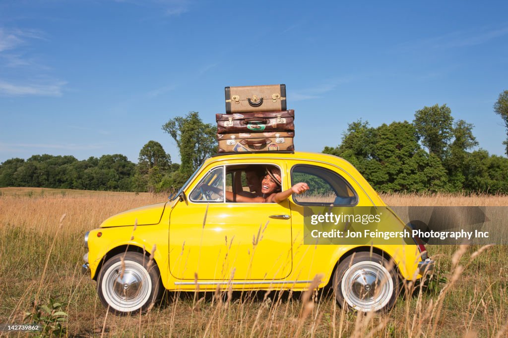 Couple in old-fashioned car on road trip