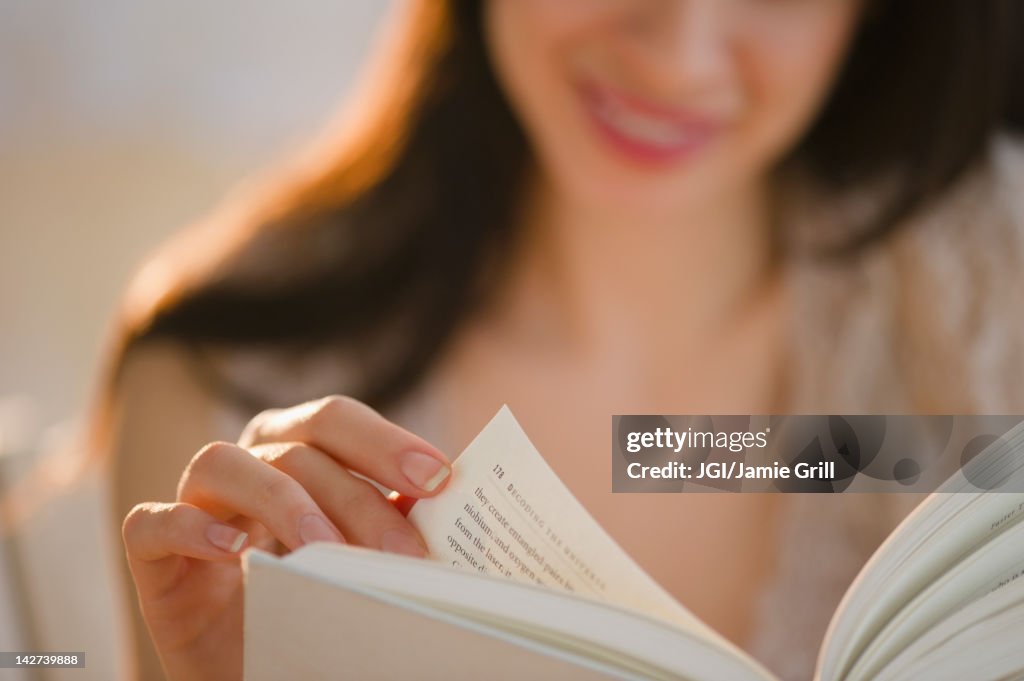 Mixed race woman reading book