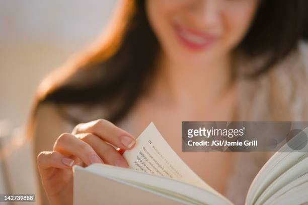mixed race woman reading book - sfogliare libro foto e immagini stock