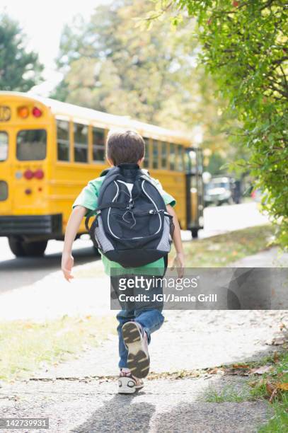 caucasian boy running after school bus - perseguir - fotografias e filmes do acervo