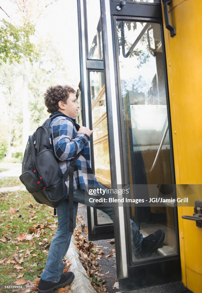 Mixed race boy getting onto school bus