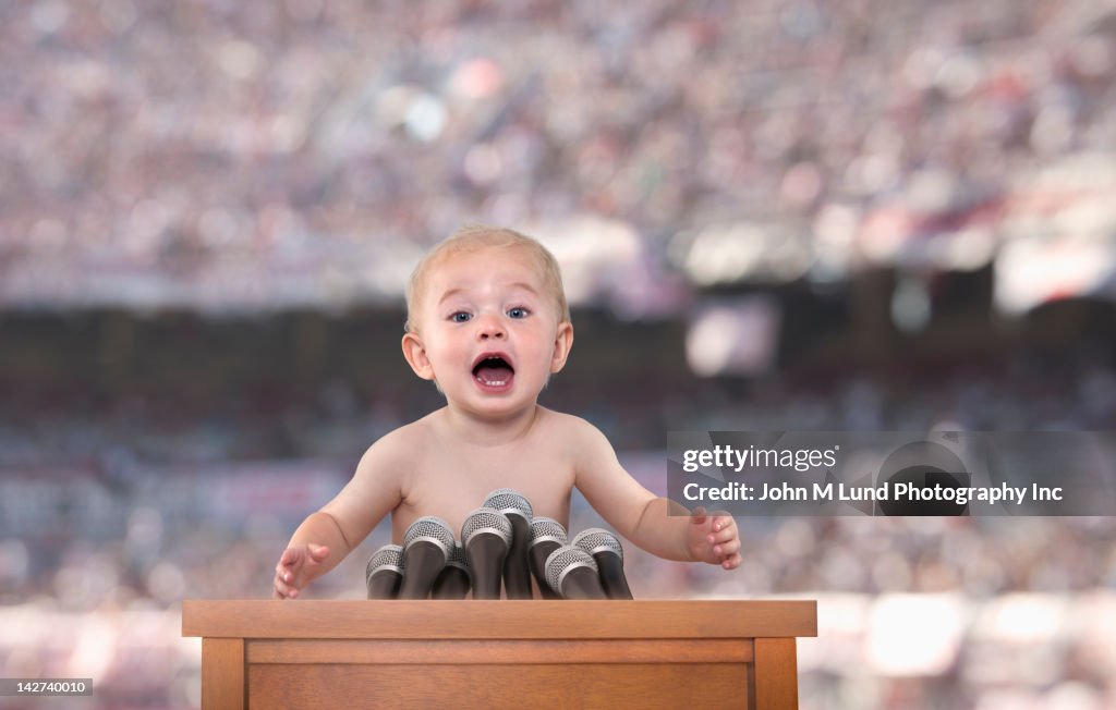 Caucasian baby speaking at podium