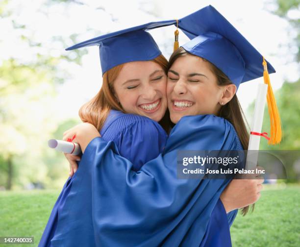 caucasian graduating teenagers hugging - secondary school certificate stock pictures, royalty-free photos & images