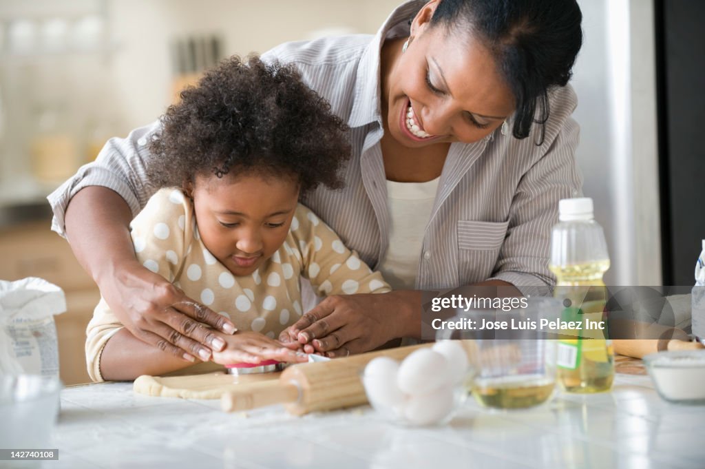 Mother and daughter baking in kitchen