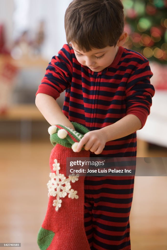 Caucasian boy looking in Christmas stocking