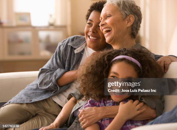 grandmother and grandchildren laughing on sofa - neto família - fotografias e filmes do acervo