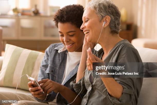 grandmother and grandson listening to mp3 player - boy ipod stock pictures, royalty-free photos & images