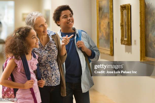 grandmother and grandchildren visiting a museum - museum tour stock pictures, royalty-free photos & images