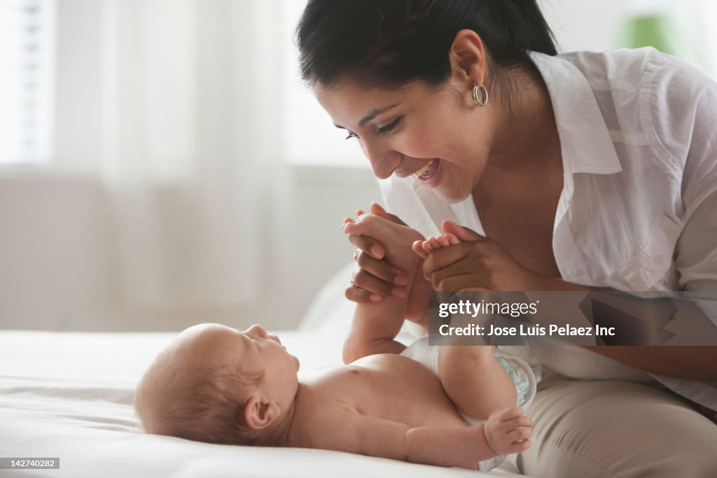 Hispanic mother playing with baby girl