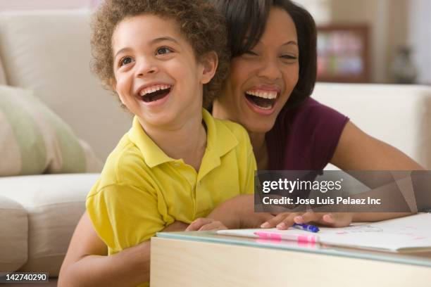 mother and son drawing together - couchtisch stock-fotos und bilder