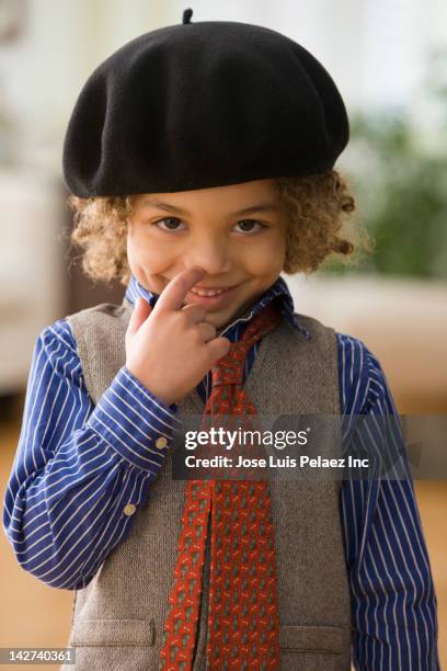 smiling mixed race boy wearing cap - beret stock-fotos und bilder