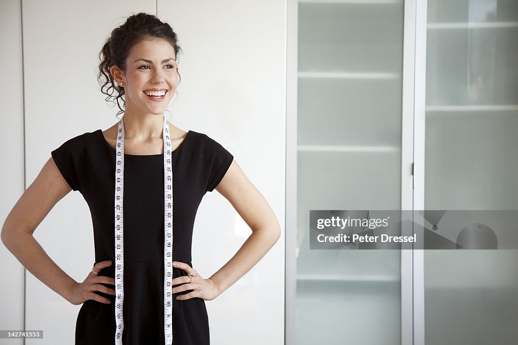 Businesswoman with measuring tape around her neck