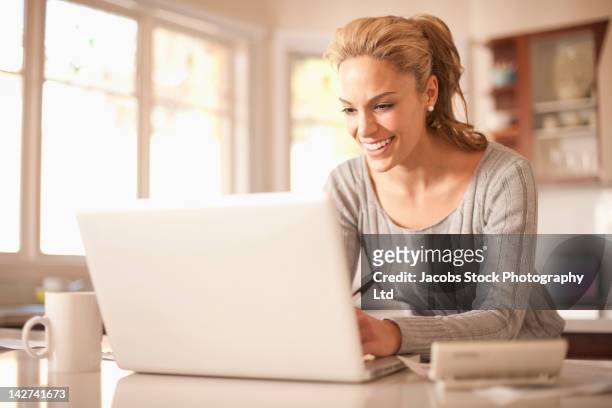 hispanic woman typing on laptop - australian economy stock pictures, royalty-free photos & images