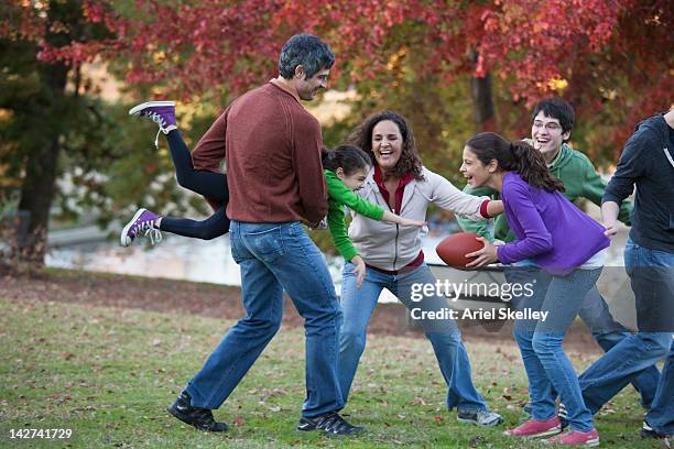 family playing football in park - mother with daughters 12 16 photos et images de collection