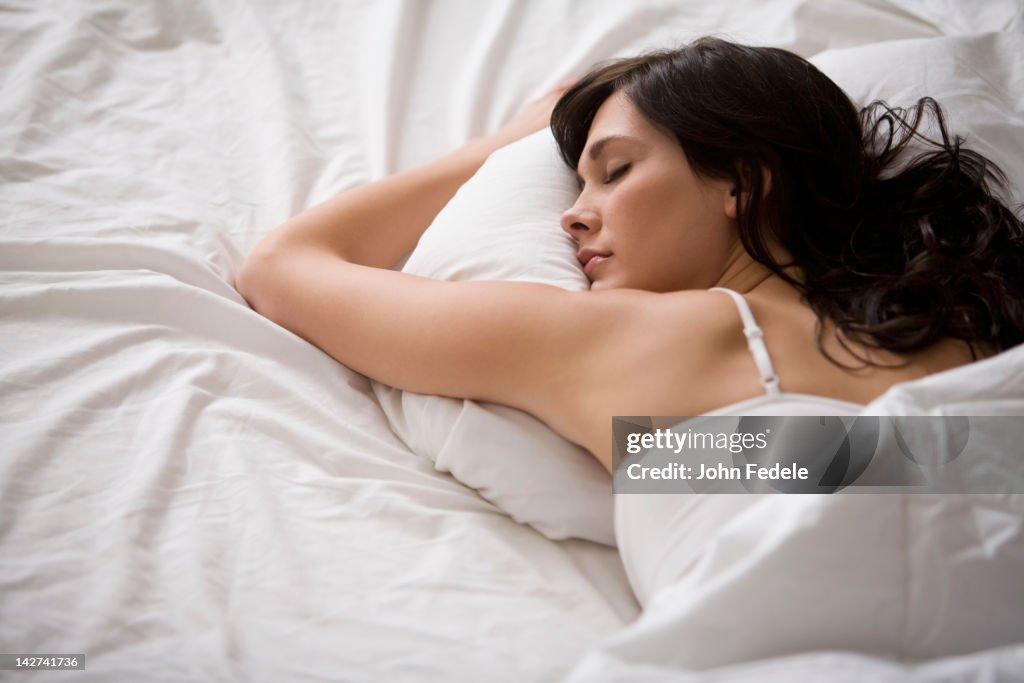 Caucasian woman sleeping in bed