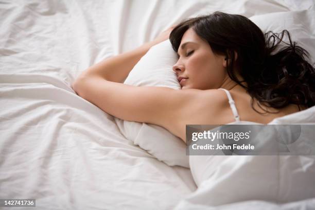 caucasian woman sleeping in bed - brunette woman bed stock pictures, royalty-free photos & images