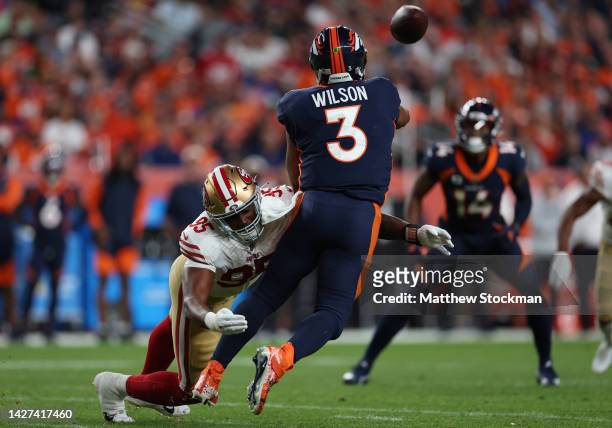 Russell Wilson of the Denver Broncos is hit by Drake Jackson of the San Francisco 49ers as he throws a pass during the first half at Empower Field At...